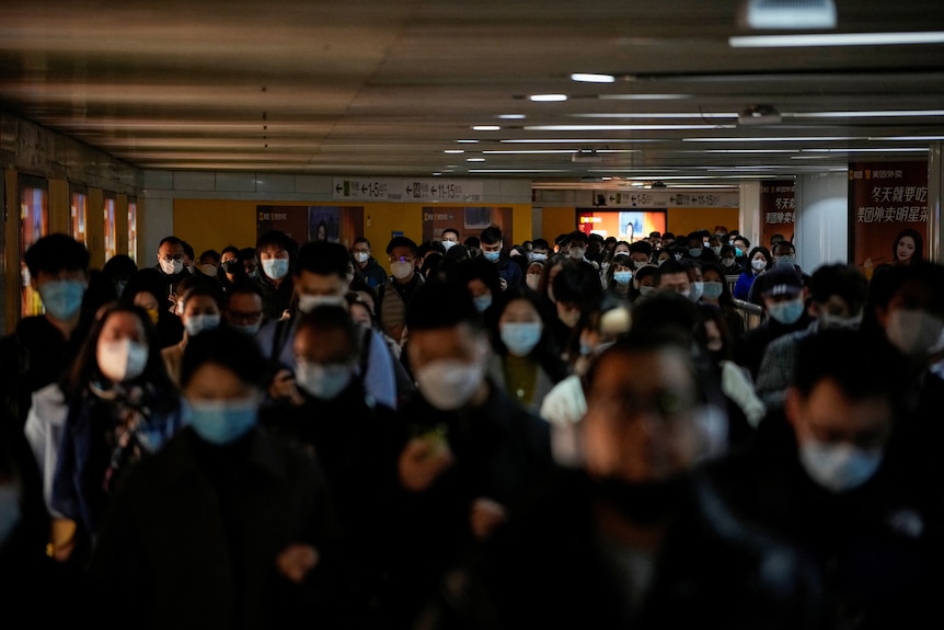 People wearing face masks walk in a subway station in Shanghai 
