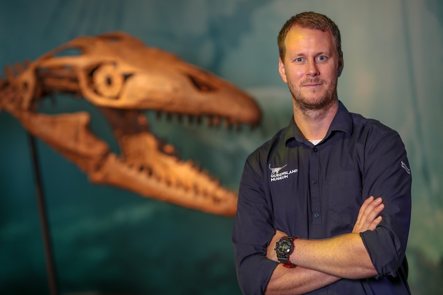 A man standing in front of fossil bones