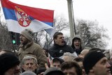 Protesters wave a Serbian flag and shout slogans during a rally in Belgrade