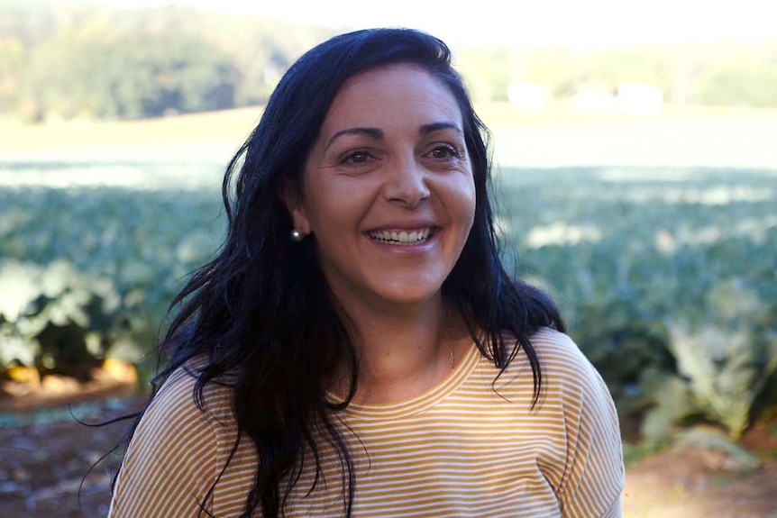 Picture of Victorian Farmers' Federation vice president, Emma Germano, with a blurred vegetable crop in the background.