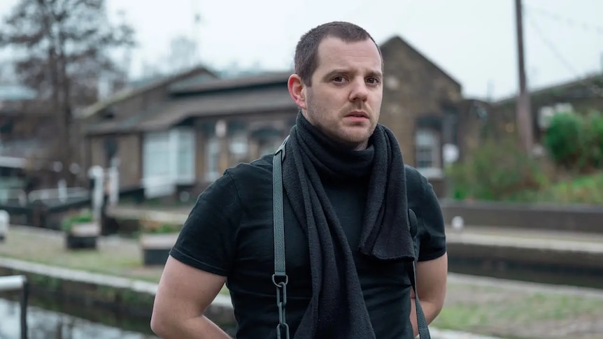 Mike Skinner of The Streets is photographed wearing a black t-shirt & scarf