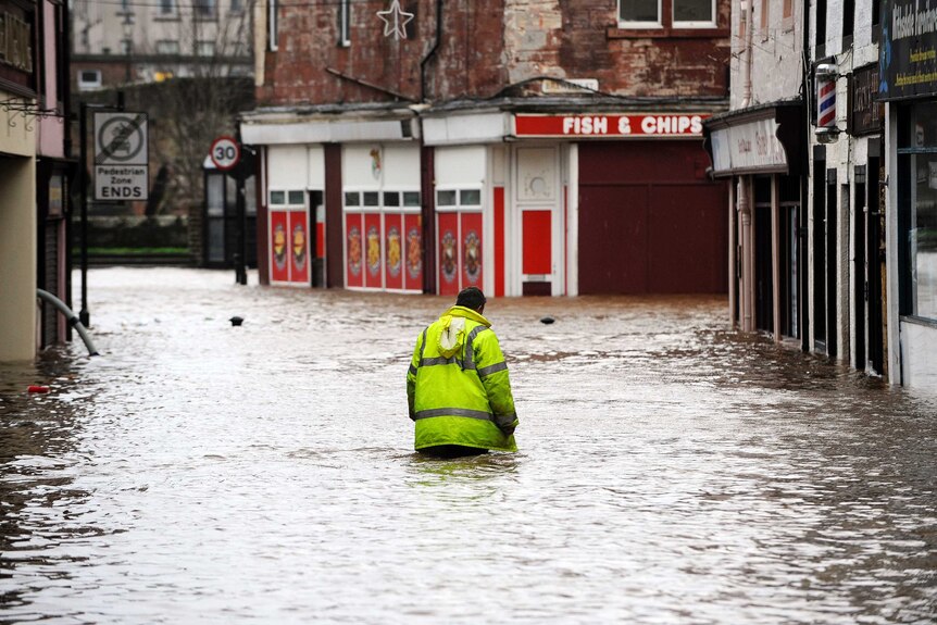 A man wades through floodwater