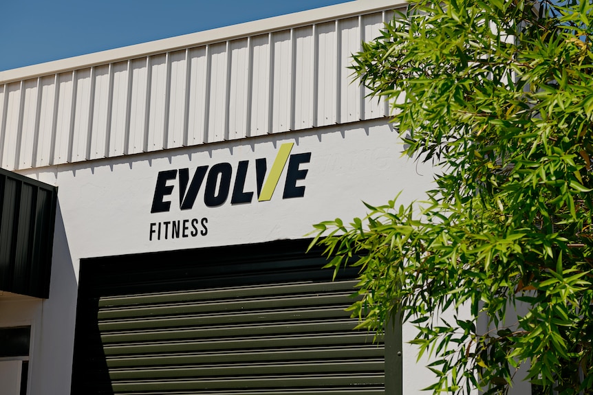 Signage for the Evolve Fitness gym in Darwin's CBD is seen above a roller door.