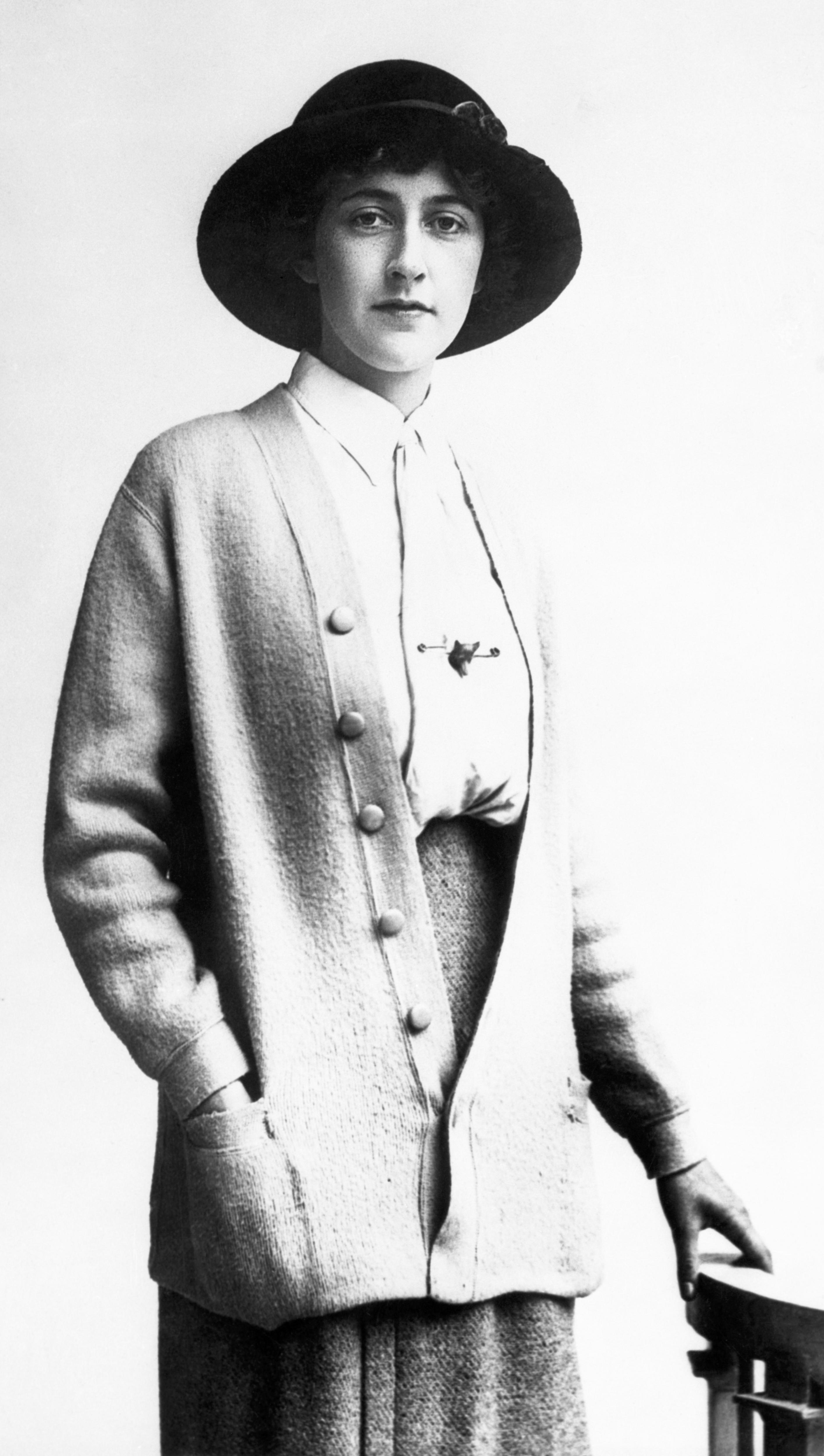 A black and white photo of a woman in a dark hat 