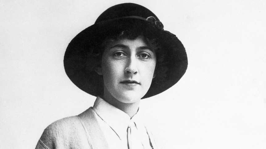 A black and white photo of a woman in a dark hat 