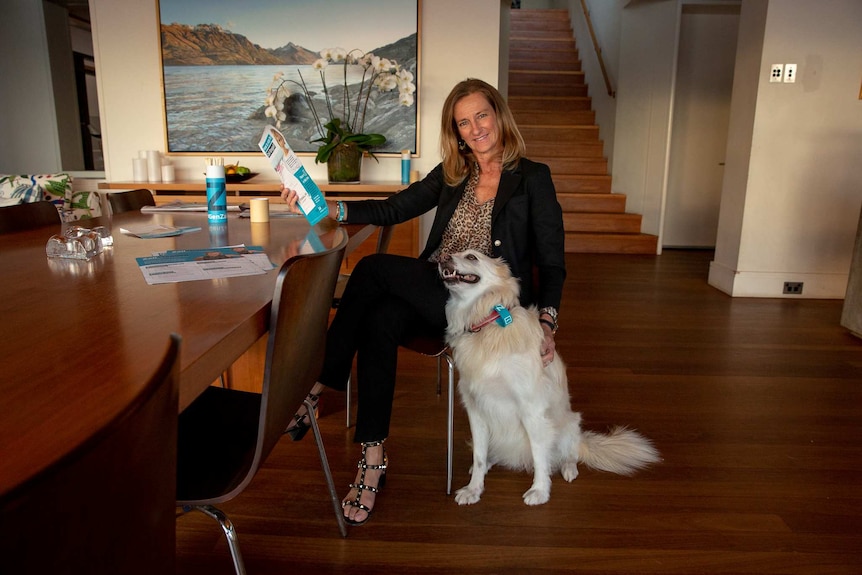 Anna Joesphson sitting with her do, she has campaign materials in her hands, she is inside her house.