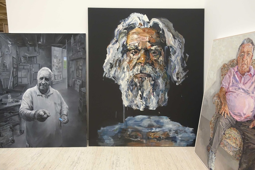 Three paintings sit in the packing room of the Archibald Prize.