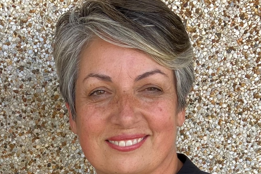 A woman with short hair smiling at the camera.