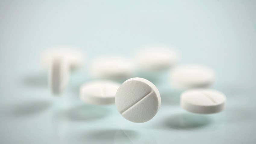 A group of while pills or tablets sitting on a table.