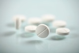 A group of while pills or tablets sitting on a table.