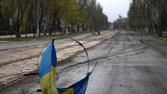 A burned Ukraine flag on the road.