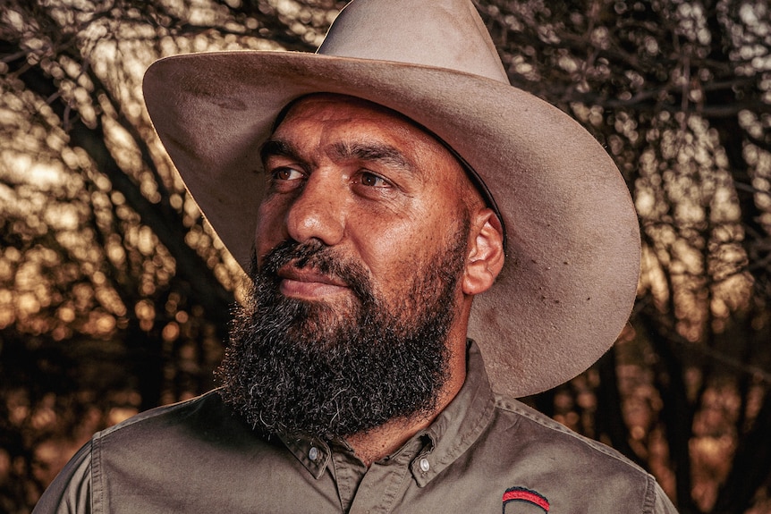 An Indigenous man with a beard wearing a wide-brimmed hat