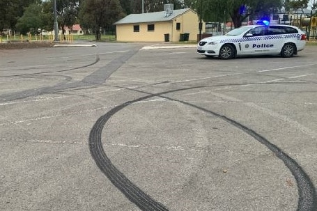 A black tyre mark from a burnout in a carpark.