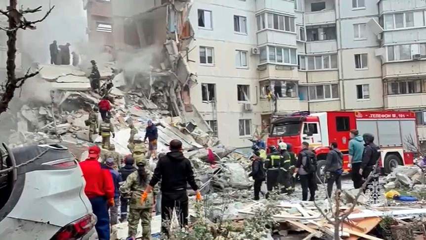 Emergency workers search through rubble after an apartment building collapsed.