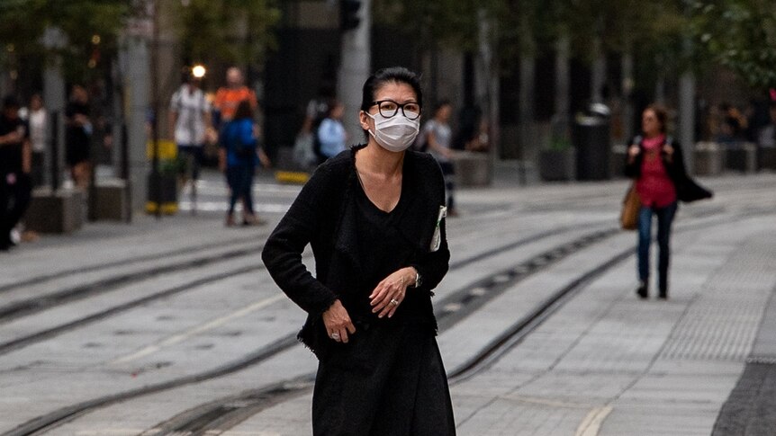 A woman in the city wearing a mask