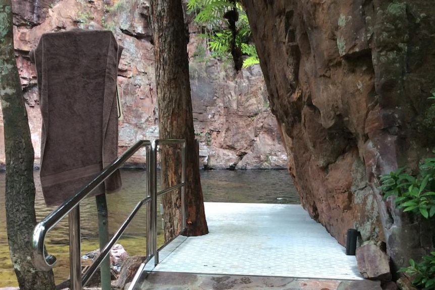 A ramp leading into a waterhole, with railing beside it