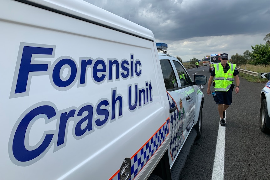 a police forensic unit and officer at the highway crash scene