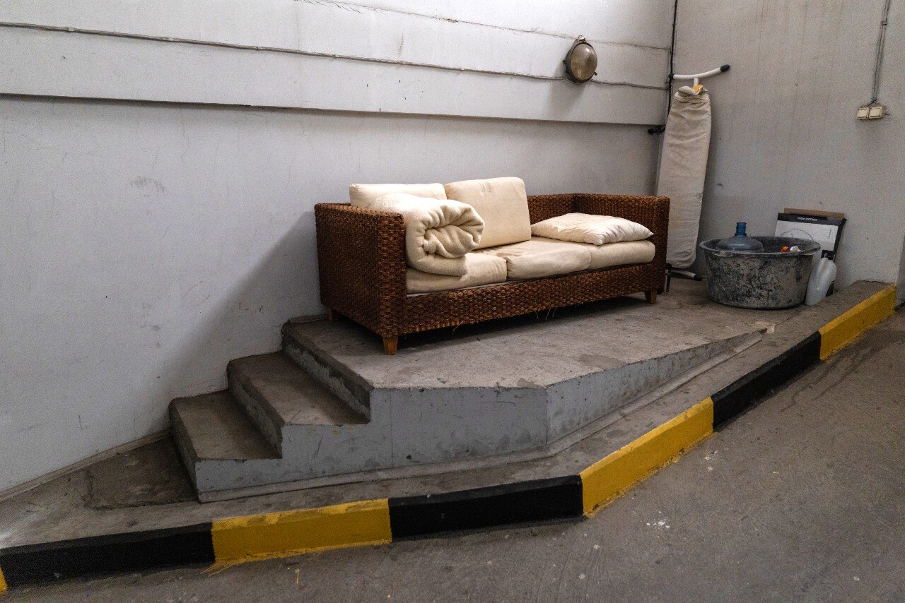 A sofa, placed in what is clearly a car park.