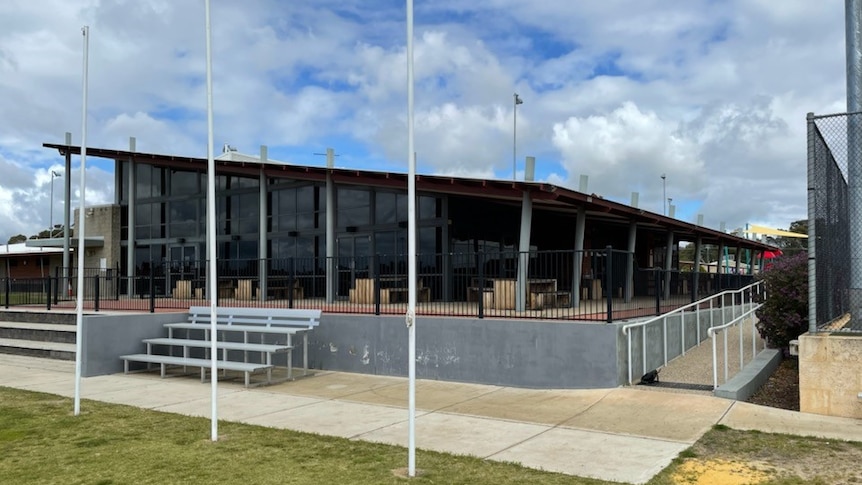 A building with football oval goal posts in front of it.