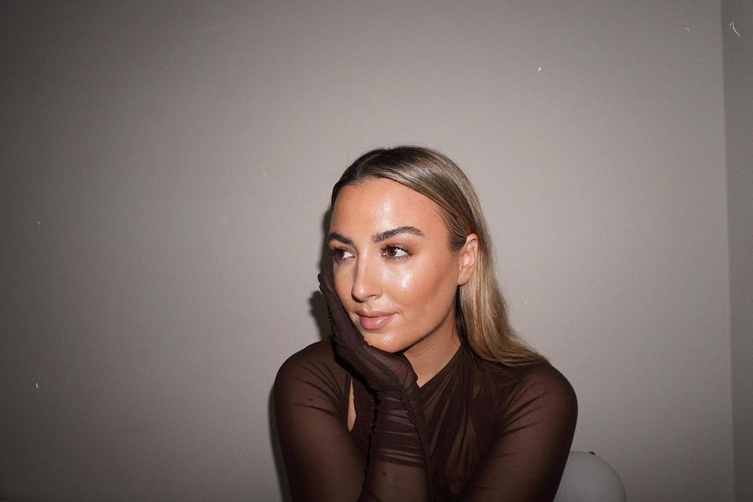 A blonde woman looks off to the side 