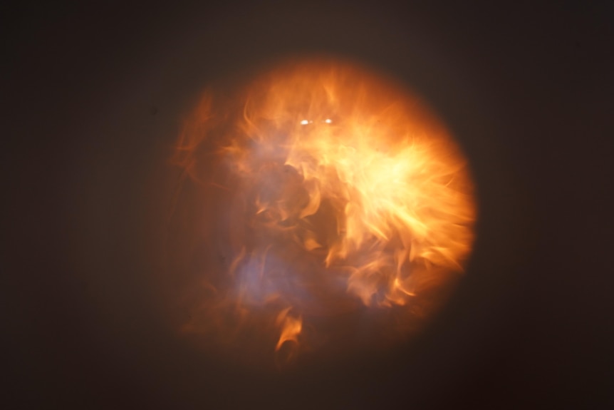 A gas flame seen through a viewing hole.