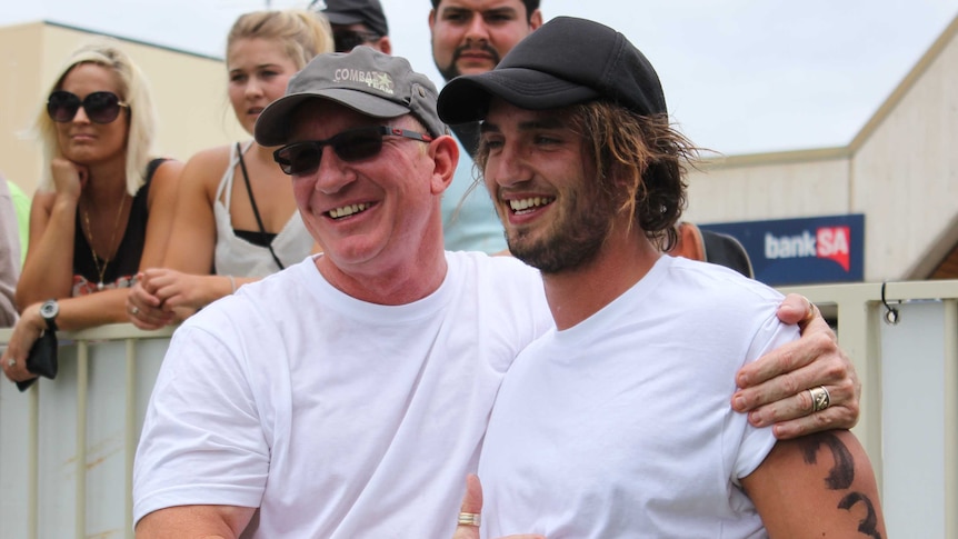 A father in a cap and sunglasses with his son after the Tuna Toss competition in Port Lincoln.