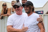 A father in a cap and sunglasses with his son after the Tuna Toss competition in Port Lincoln.