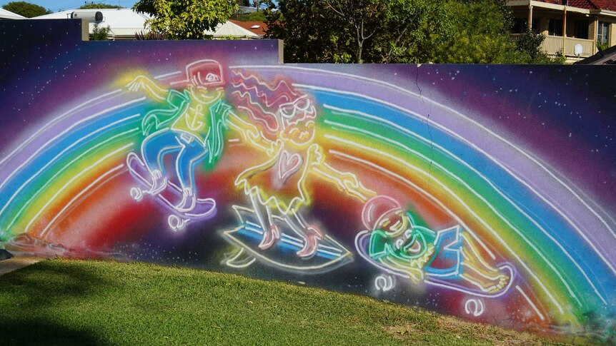A rainbow painting depicting three children skateboarding