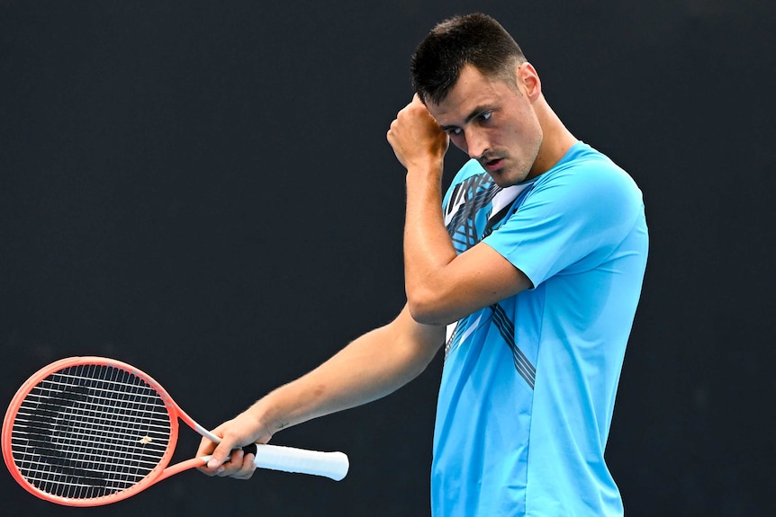 Bernard Tomic looks towards the ground during his Australian Open match against Yuichi Sugita.