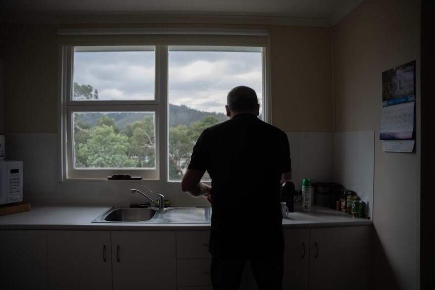 Michael Reardon's silhouette in his kitchen as he wipes down the sink.