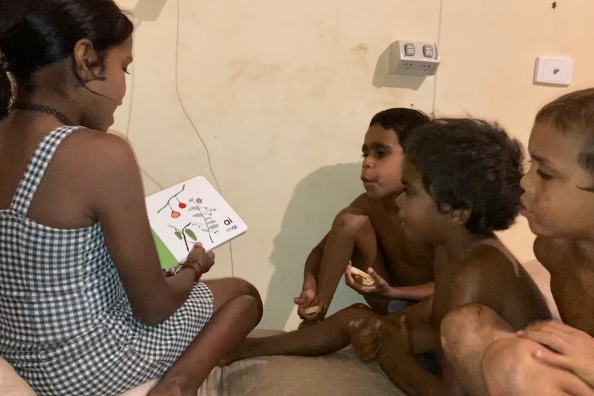 Anangu children reading a picture book which was launched across the APY Lands. 