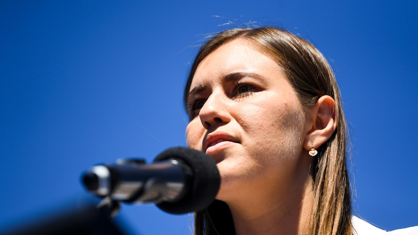 A woman speaking in to a microphone. 