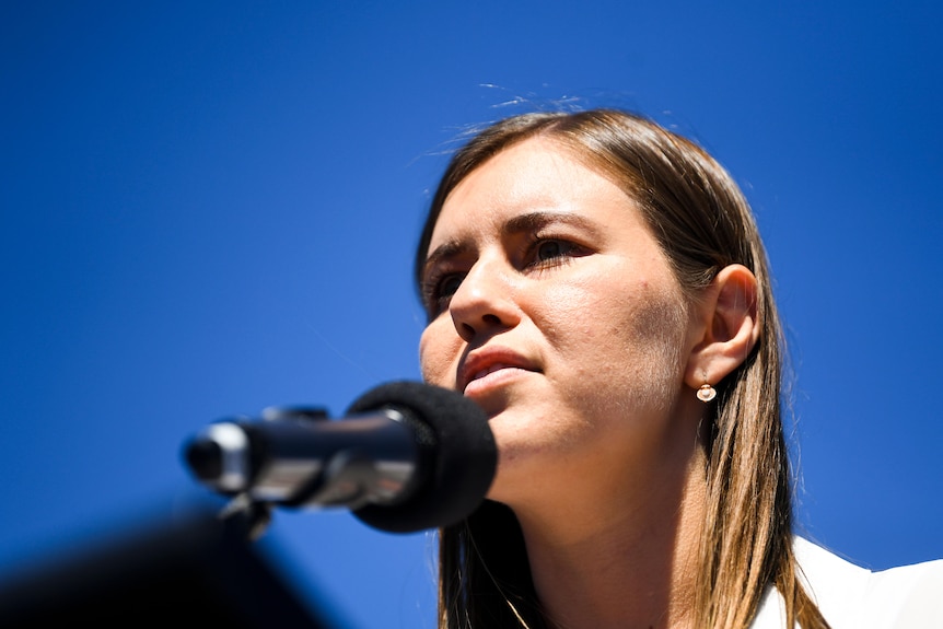 A woman speaking in to a microphone. 