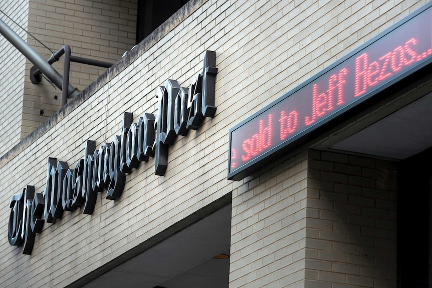 An announcement that The Washington Post has been sold is made outside the Post's office.