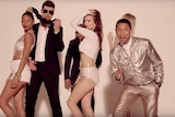 Robin Thicke and Pharrell Williams wearing suits with three women wearing revealing clothing in the film clip for Blurred Lines