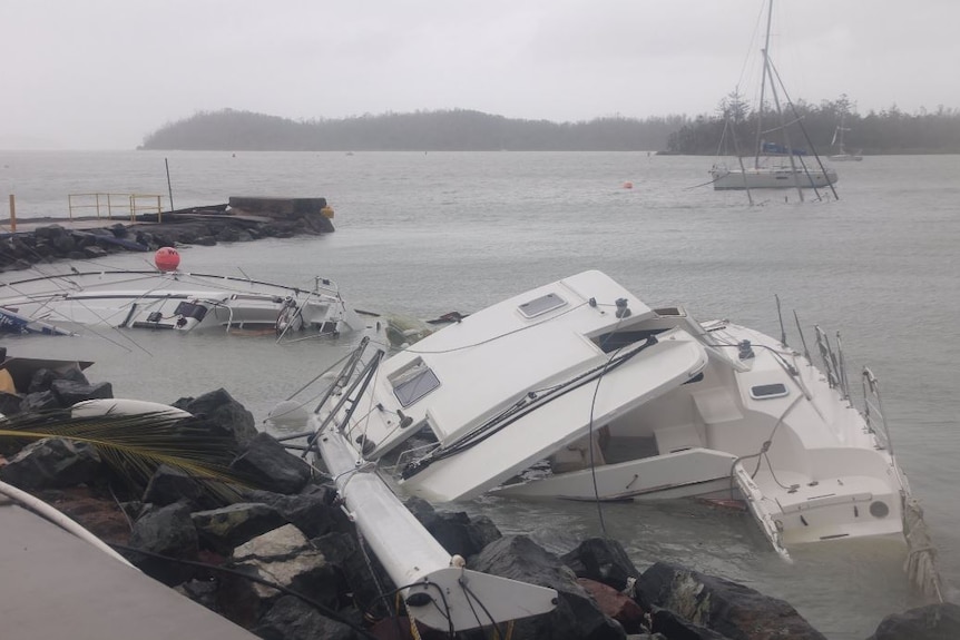 Two boats partially submerged at Shute Harbour at Airlie Beach.