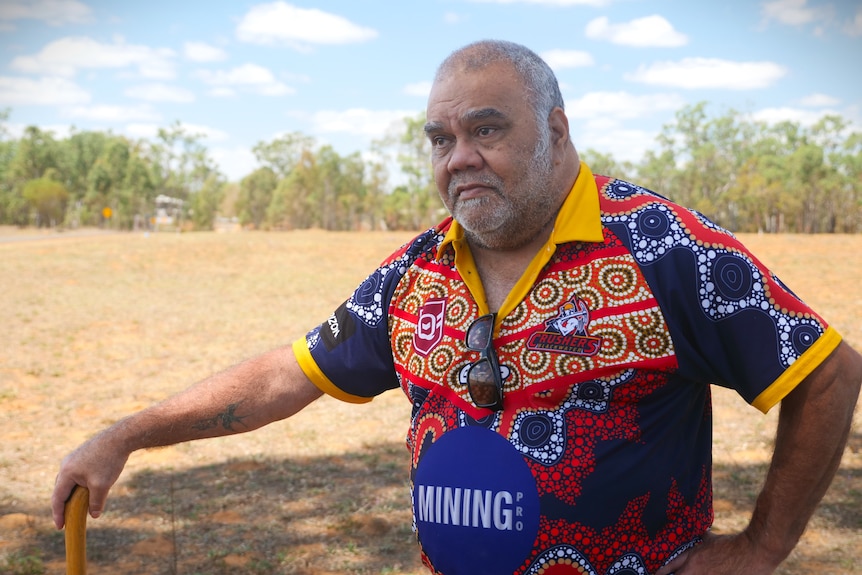 Man in colourful shirt in a field.