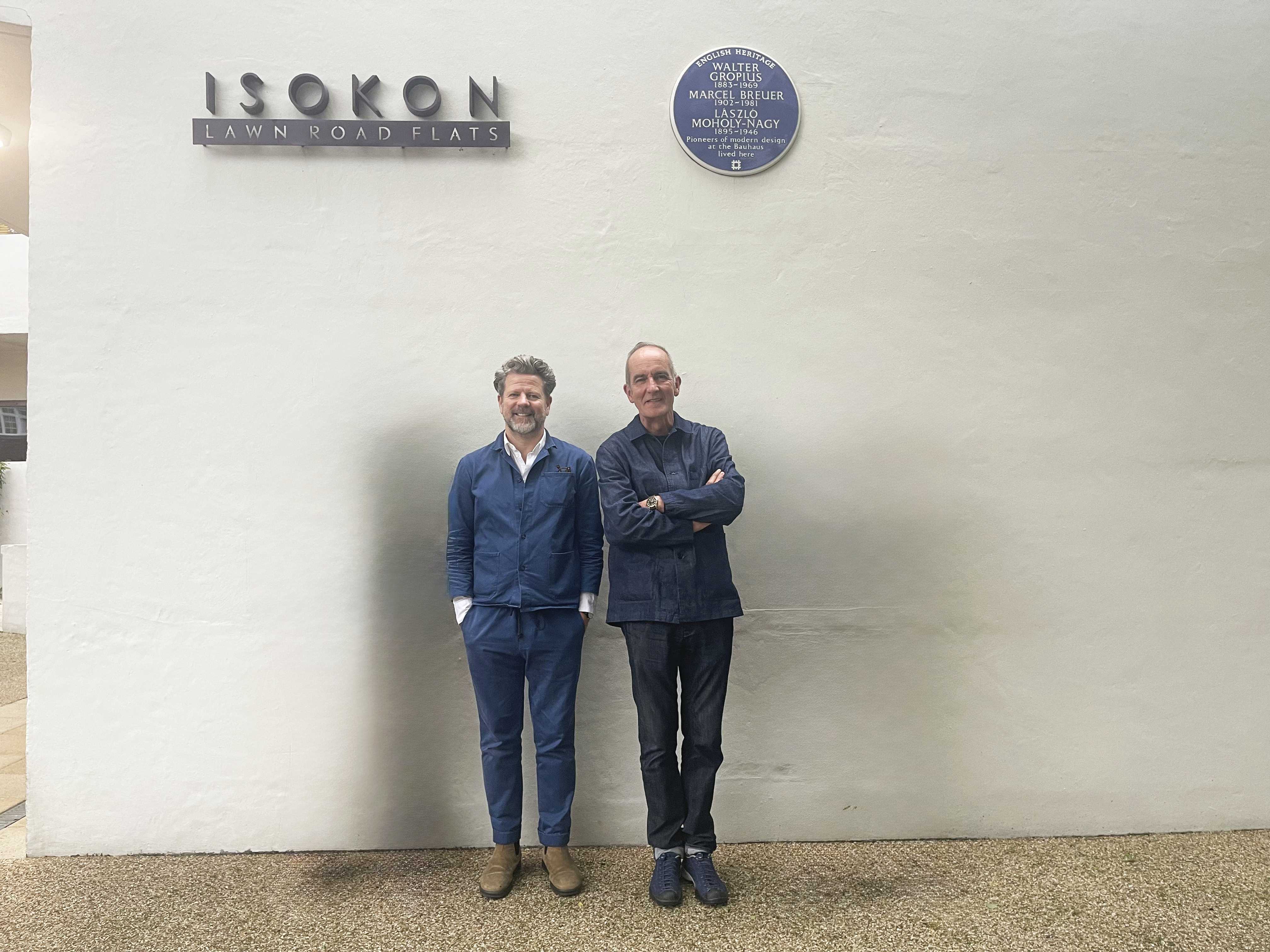 Kevina y Tim se paran contra una pared y sonríen a la cámara.
