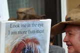 A cattle farmer talks with an animal rights activist on the steps of the West Australian parliament.