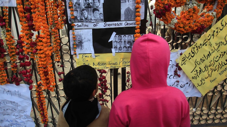 Children look at pictures of victims of Tuesday's attack on Army Public School in Peshawar December 21, 2014