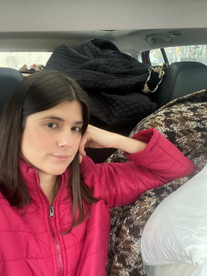 a woman in a car that's full with clothing