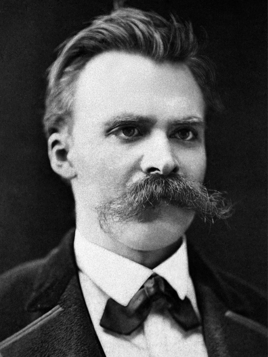 A black and white photo of a man with a very bushy moustache. 