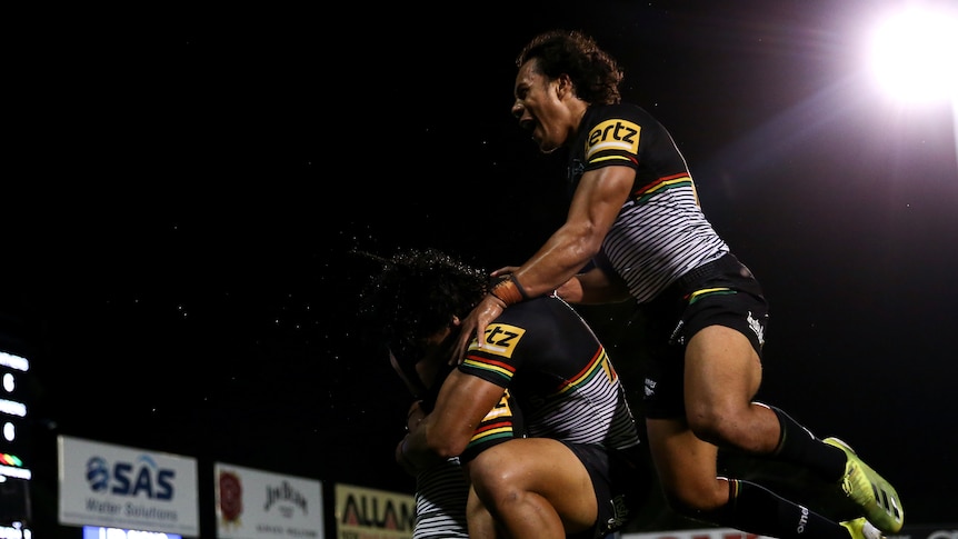 Penrith panthers players celebrate by jumping on top of each other