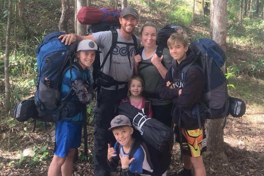 Four children and two adults with hiking gear on