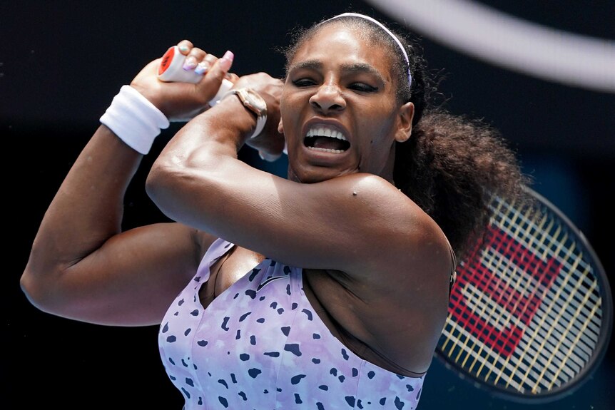 Serena Williams screams as she hits a shot with both hands