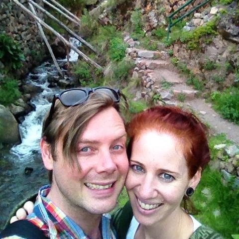 Man and woman take a selfie beside a creek
