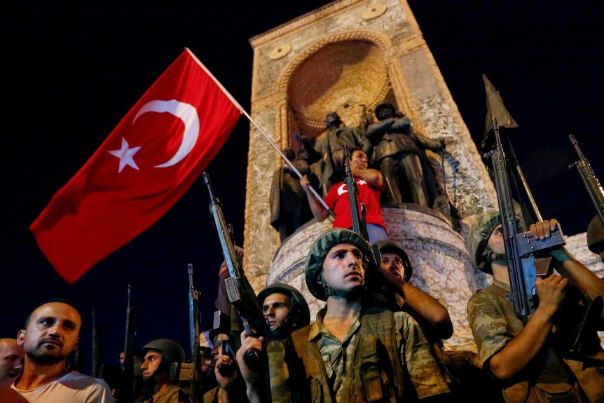 Demonstrators in Istanbul waving a Turkish flag and holding guns.