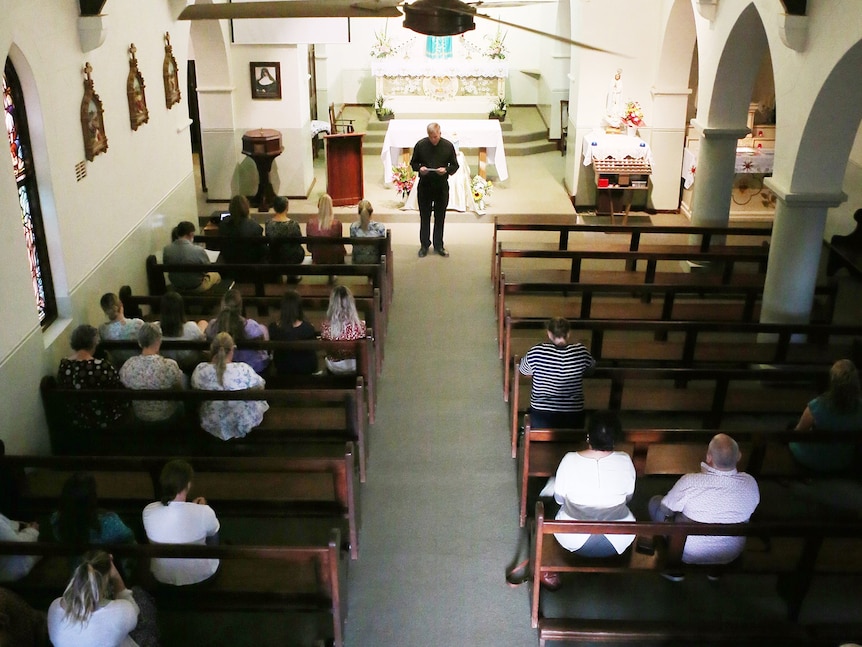 The inside of a church during a prayer service with about 20 people in attendance