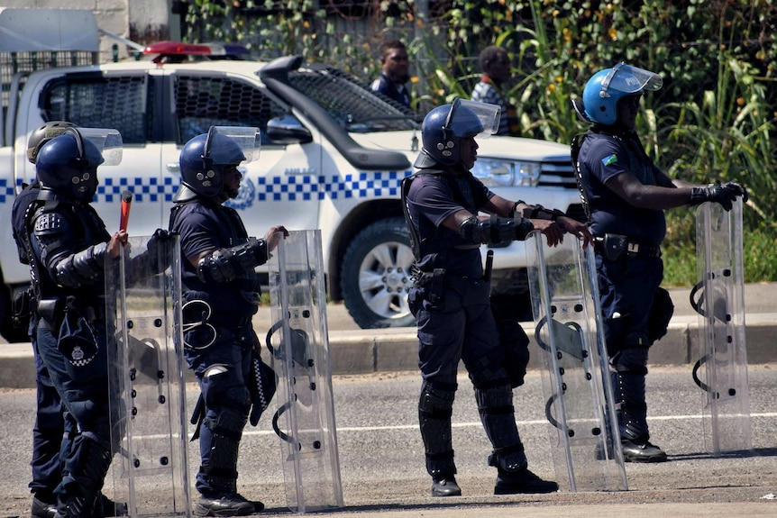 Riot police stand in the road in Honiara amid post-election unrest in Solomon Islands.