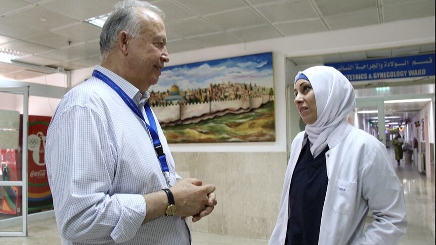 Makassad Hospital director Rafik Husseini talks to one of his staff in a hospital corridor.